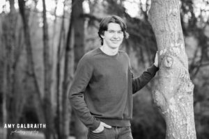 high school senior leaning against a tree