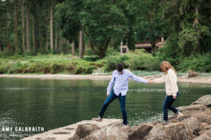 guy helping girl onto rocks during engagement photos