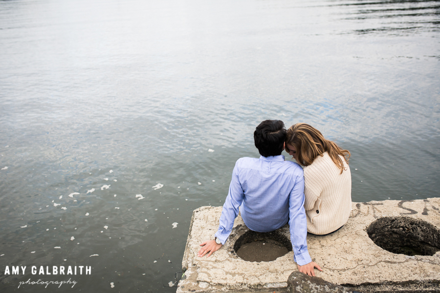 girl leaning onto guy's shoulder during engagement photos by the water