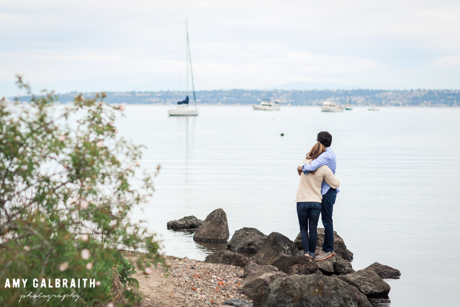a couple hugs with a view of blakely harbor