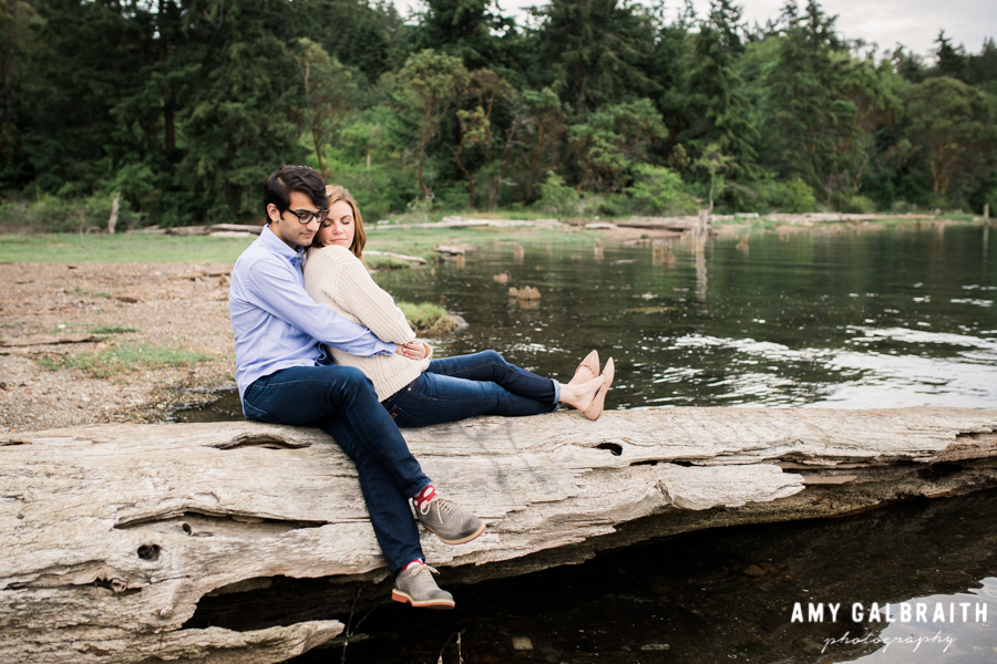 couple snuggling on a log at blakely harbor park