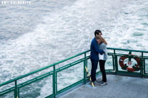 couple standing on the back of washington ferry boat to seattle