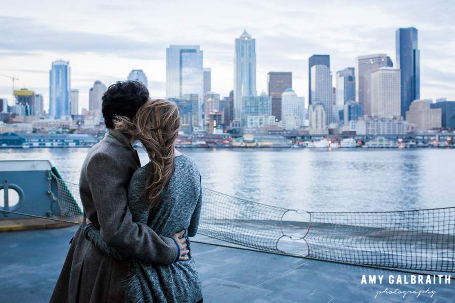 couple embracing at twilight in front of Seattle skyline on a ferry