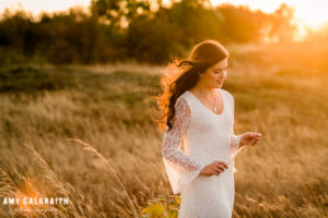 high school senior in white dress in the tall grass at Discovery Park