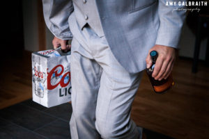 groomsman holding beer and whiskey