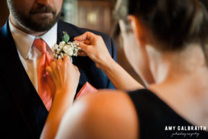 groom getting his boutonniere pinned on