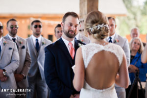 groom watching bride as she reads her vows