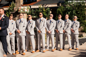 groomsmen watching wedding ceremony wearing navy and grey