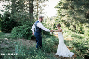 bride holding groom's had in the woods at swiftwater cellars