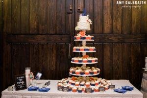 cupcakes and a small wedding cake with wooden silhouette cake topper