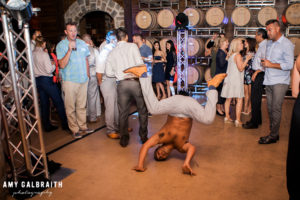 guy doing a summersault at wedding reception