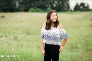 high school senior wearing peasant shirt in a field at discovery park