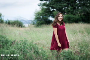 high school t-shirt in maroon dress in tall grass at discovery park