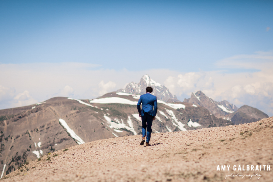 groom with grand teton in background on mountain top