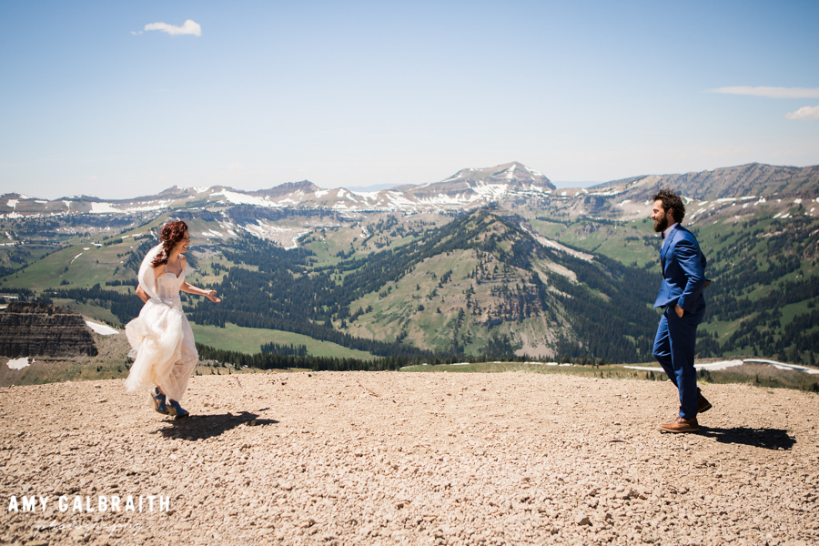 bride runs toward groom for first look on mountain top in jackson hole