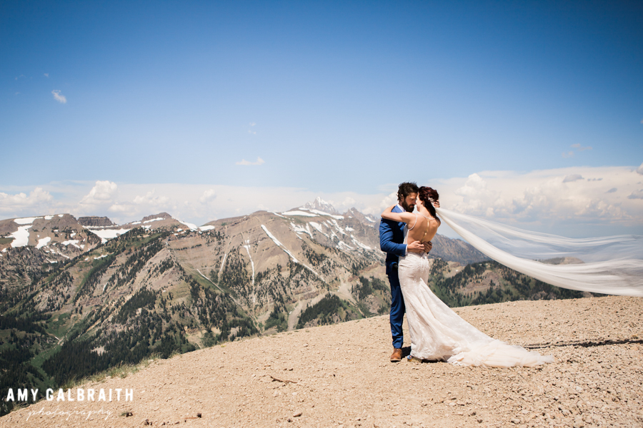 bride and groom with the tetons and long veil with boho dress