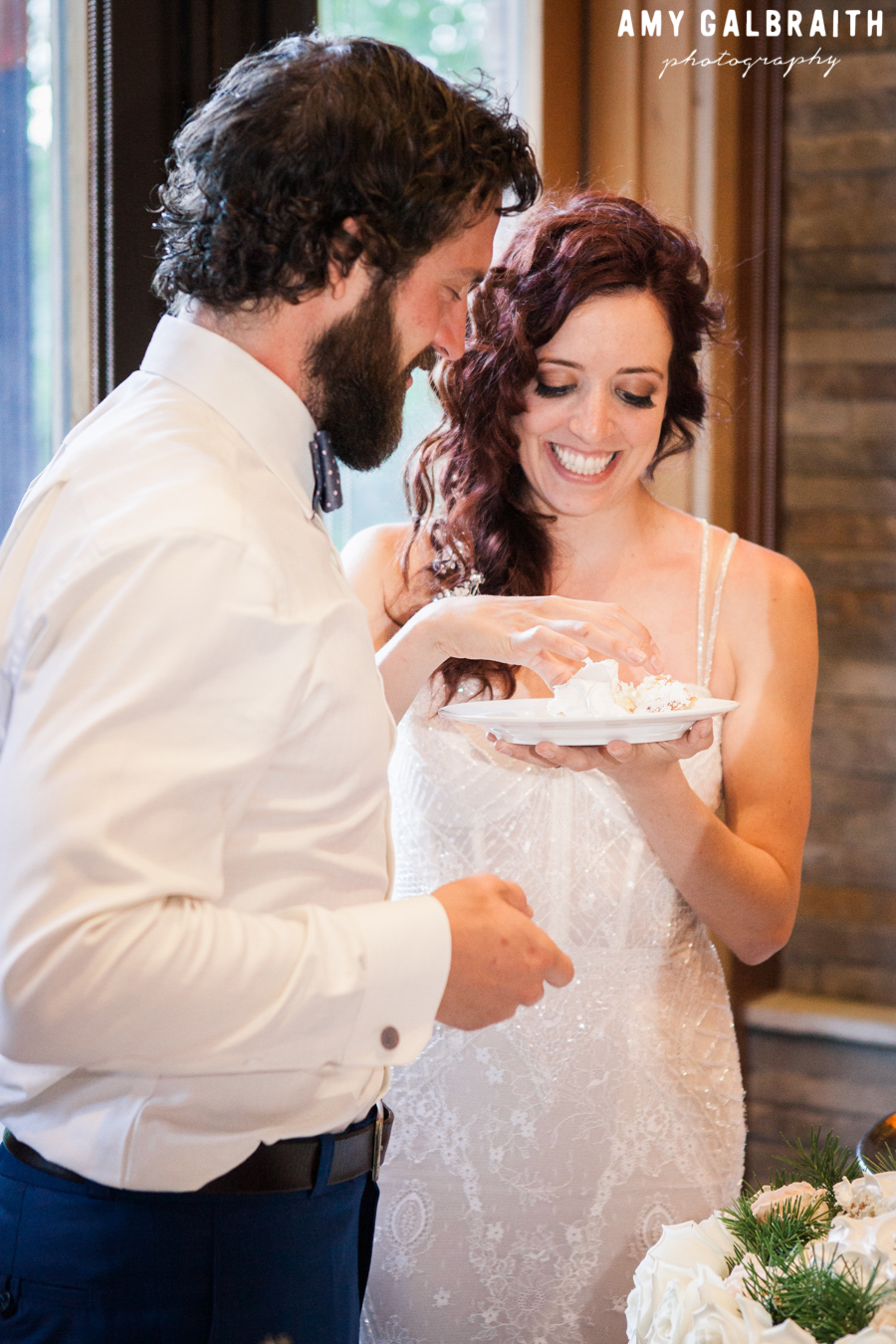 bride and groom eating cake at wedding reception