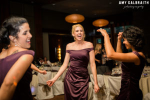 bridesmaids wearing purple dancing at wedding reception