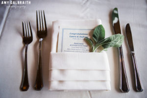 wedding menu with sprig of sage tucked into napkin