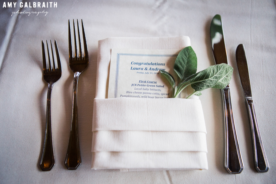 wedding menu with sprig of sage tucked into napkin