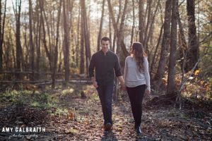 couple walking through the tall woods in the fall
