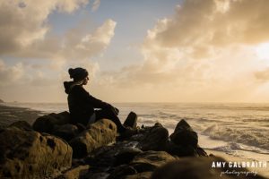 girl in beanie enjoying sunset at beach 4 in olympic national park