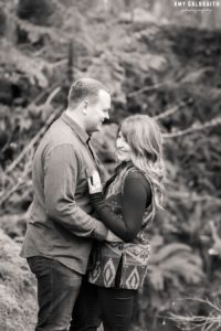 black and white candid image of a couple in the woods