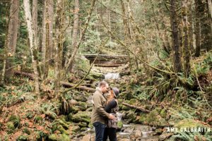 a couple near the river during their fall engagement session at Stevens Pass