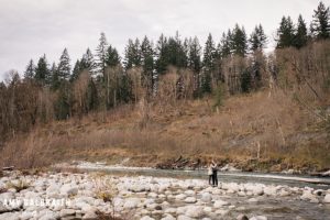 a couple standing near the river during their stevens pass engagement session