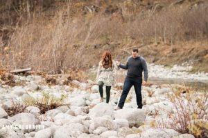 a couple walking along the river during their engagement session at stevens pass