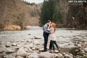 a couple kisses next to the river in skykomish washington
