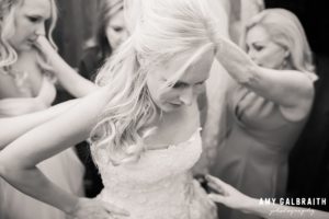 bride getting dressed in her oscar de la renta gown