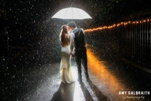 bride and groom in the rain at night at the manor house at pleasant beach