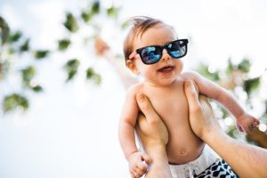 3 month old baby being held up in the palm trees