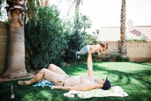 father holding baby in the air with one hand