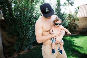 father holding baby with sunglasses