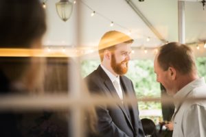 a groom anticipates his wedding ceremony greeting guests