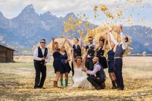 wedding party throwing leaves with the tetons in the background