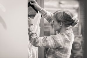 bride taking wedding gown off of hanger