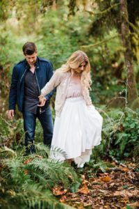 a trendy couple walks through the woods at manchester state park