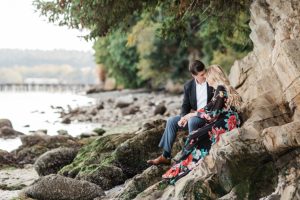 couple sits together on the beach rocks at manchester state park