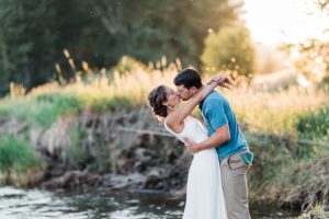 bride and groom kissing along the river in twisp, washington