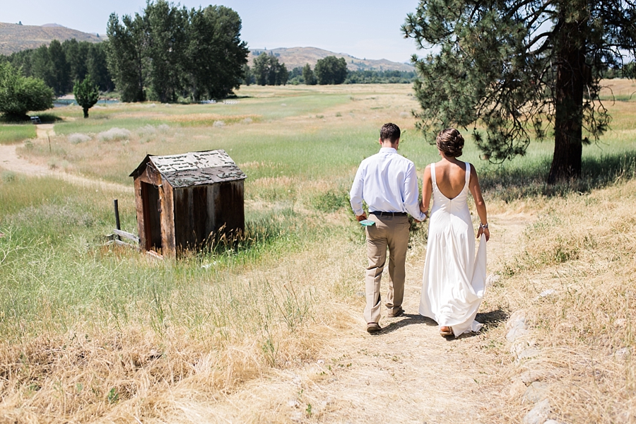 bride and groom walk down a trail in the methow valley