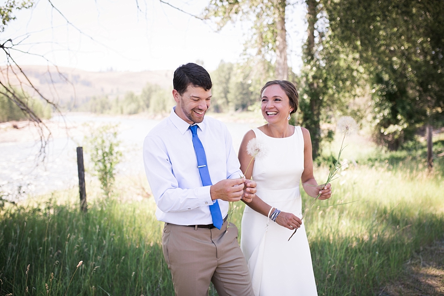 bride and groom play with dandelions in mountain wedding in twisp