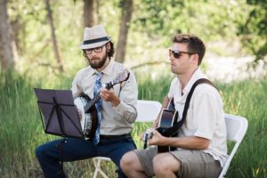 two men play acoustic guitar at a wedding in twisp