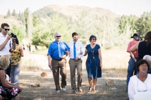 groom's parents walk him down the aisle