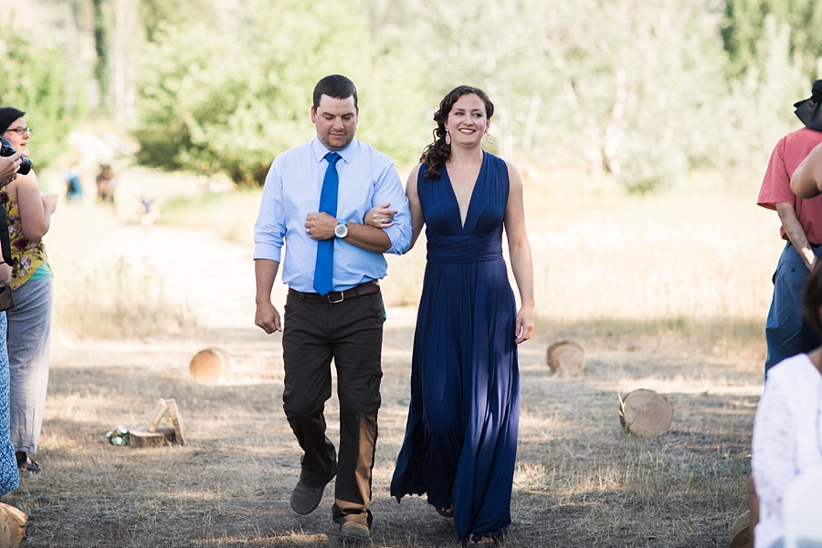 bridesmaid wearing navy and groomsmen in blue walk down the aisle