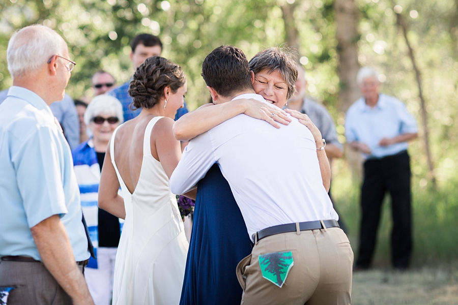 groom hugs bride's mother during ceremony