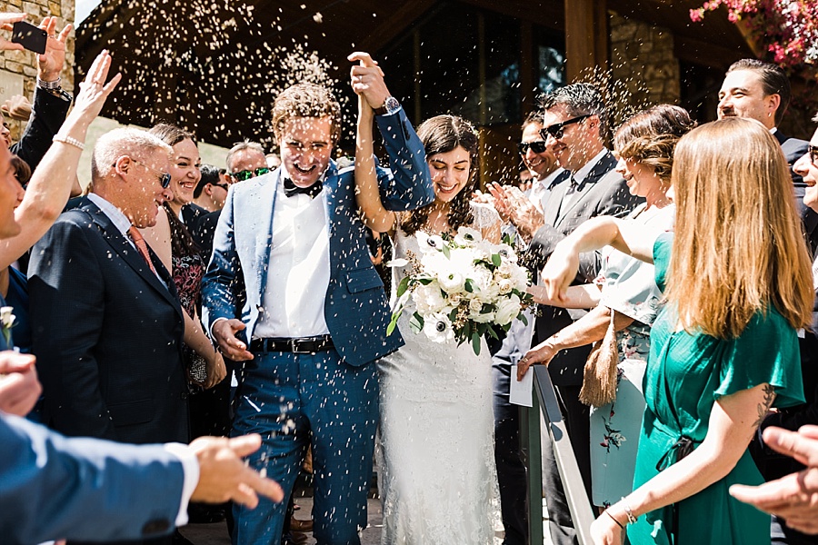 bride and groom walking back down the aisle being showered by lavendar during jackson hole wedding recessional