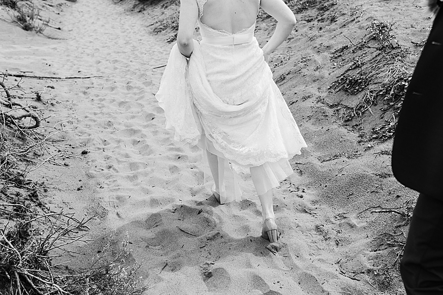A bride hikes on a sandy beach on her wedding day in Washington